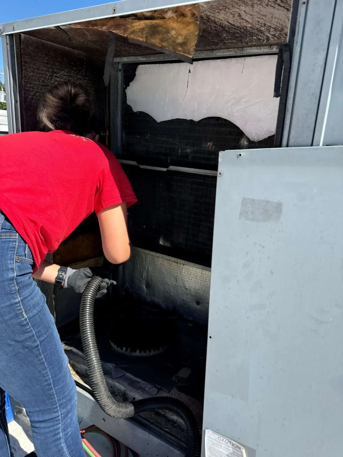 Tadlock Heating & Air team member working inside an HVAC unit