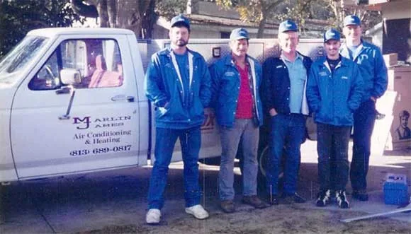 Early Marlin James crew beside a company service truck