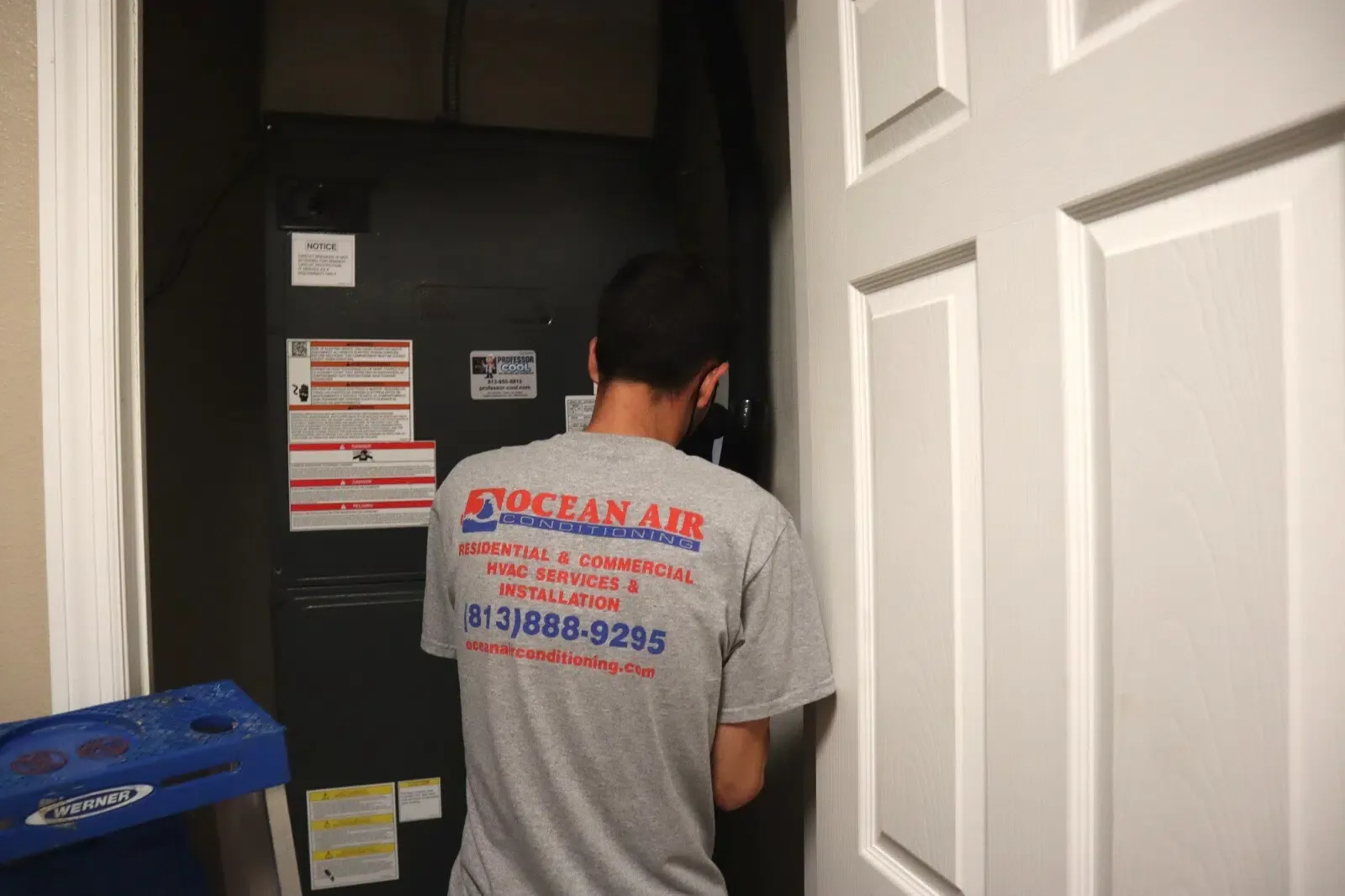 Ocean Air technician in a company shirt working at an indoor air handler