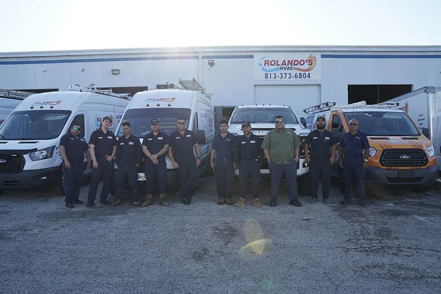 Rolando's HVAC team in front of the company vans