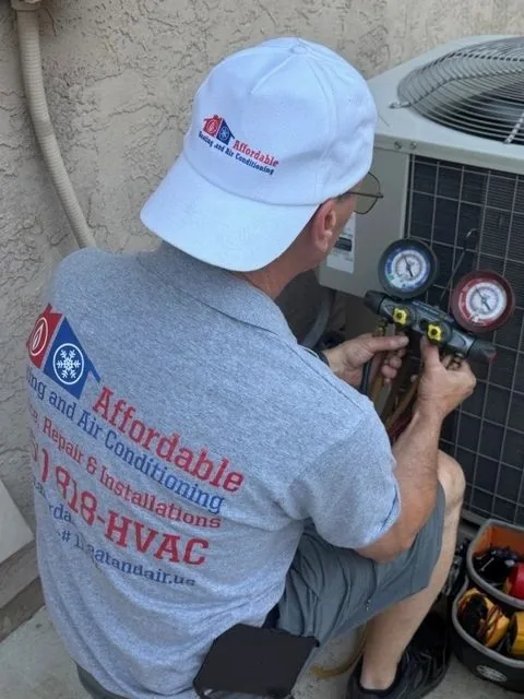 Affordable Heating and Air Conditioning technician checking refrigerant pressures on an outdoor unit