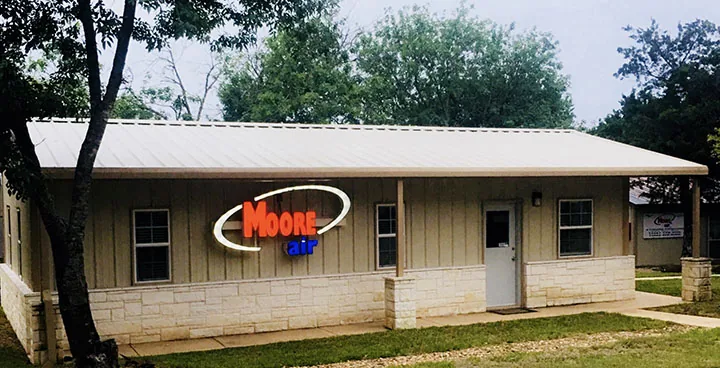Moore Air office building with its lit sign in Belton