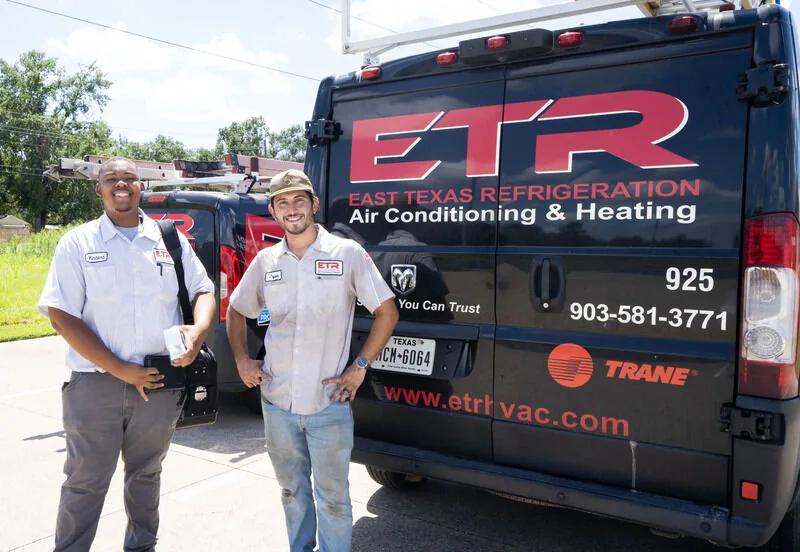 Two ETR technicians beside a branded ETR service van