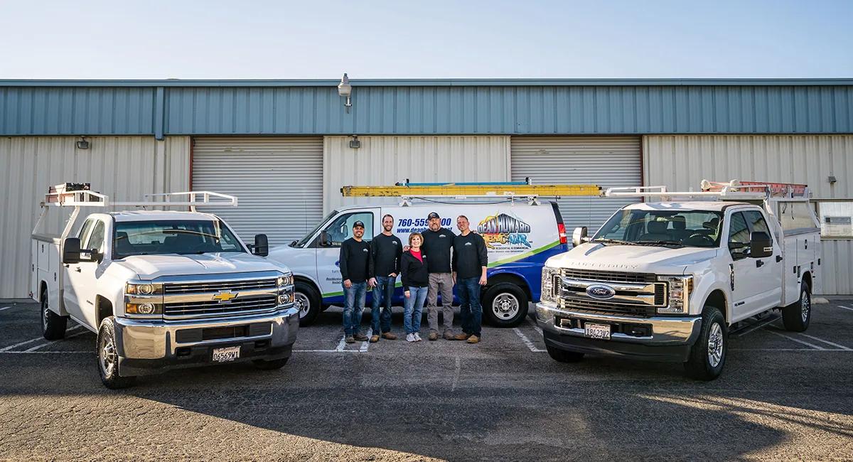 Dean Howard Heat & Air team with service trucks outside the shop