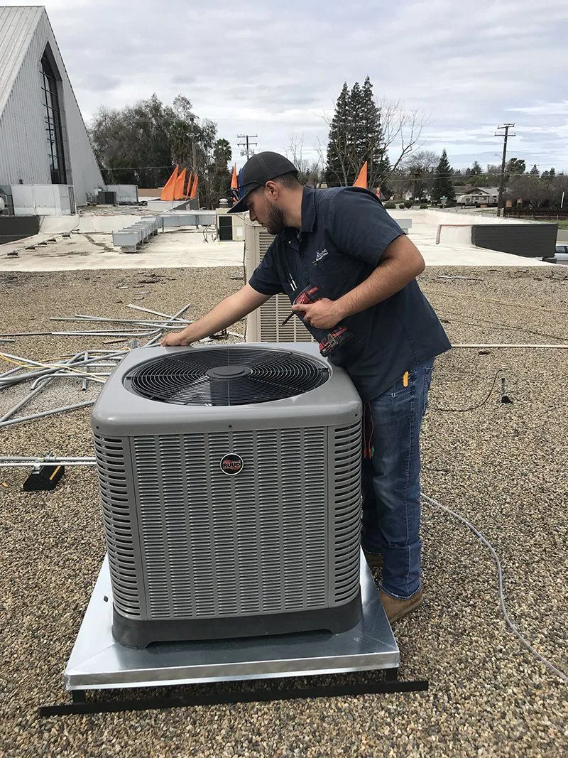 Stevens Refrigeration technician installing a condenser on a commercial roof