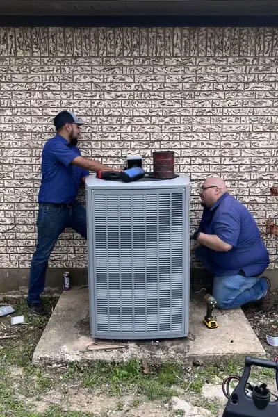 Two Centroplex technicians servicing an outdoor air conditioning unit