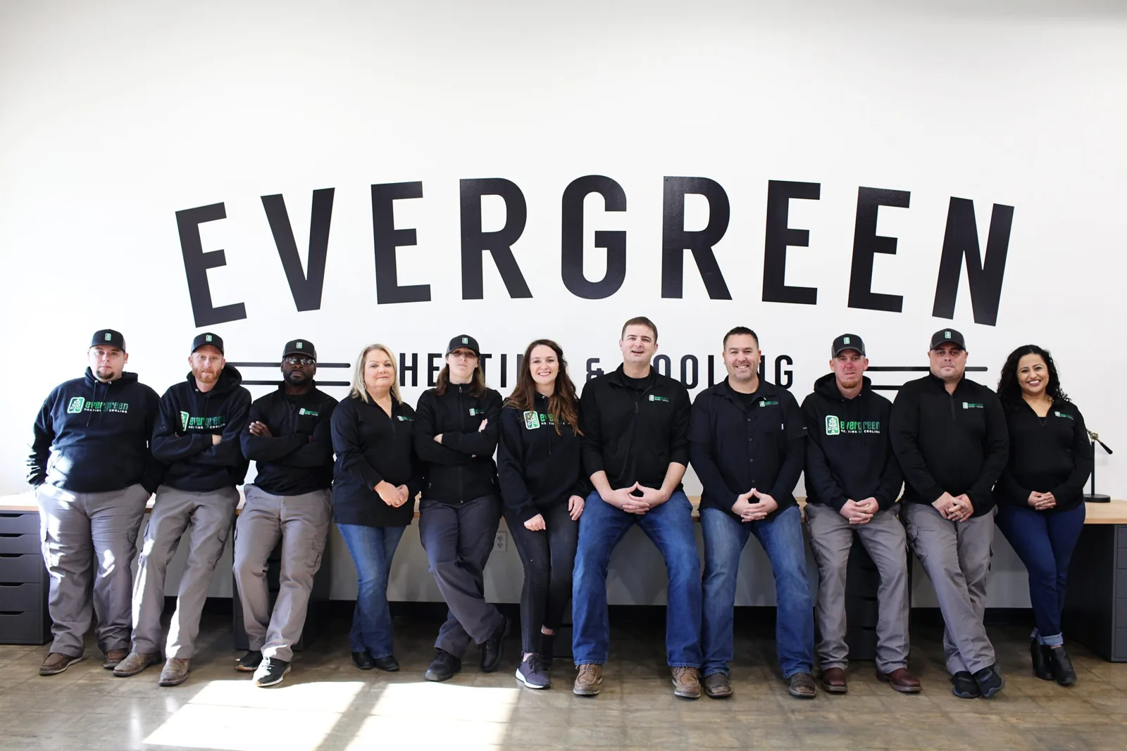 Evergreen Heating & Cooling team in front of the company sign
